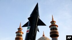 Manifestan Iranyen pote model yon misil nan Teheran, 15 Avril 2024. 