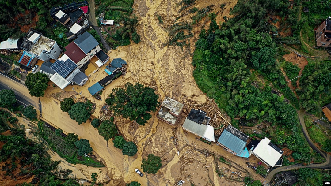 Sebuah mobil melaju melewati lokasi tanah longsor setelah badai di Longyan, provinsi Fujian, China timur, 17 Juni 2024. (CNS / AFP) 