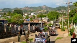 FILE - Army officers stand guard as police officers patrol in Lashio, northern Shan State, Myanmar, May 29, 2013. Ethnic armed groups claimed on July 25, 2024 to have captured the strategically important towns of Lashio and Mogok. 