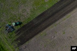 A tractor harvests a field in Potomkyne, Kherson region, Ukraine, April 25, 2023.