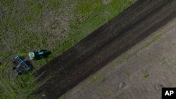 Un tractor cosecha un campo en Potomkyne, región de Kherson, Ucrania, 25 de abril de 2023.