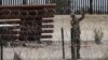 A member of the Texas National Guard installs a barbed-wire barrier on the border between El Paso, Texas and Ciudad Juárez, as seen from Ciudad Juárez, Mexico, May 3, 2023.