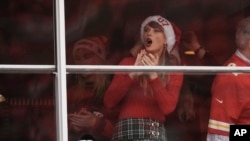Taylor Swift is seen in a suite before the start of an NFL football game between the Kansas City Chiefs and the Las Vegas Raiders Monday, Dec. 25, 2023, in Kansas City, Mo. (AP Photo/Charlie Riedel)