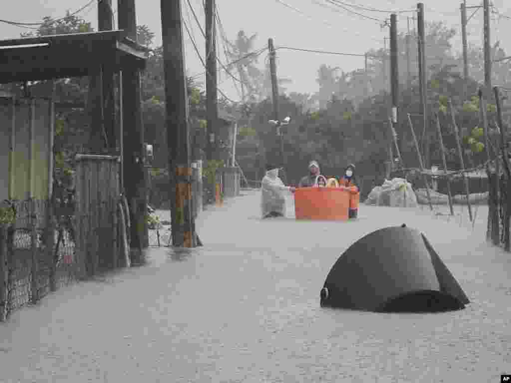 This photo released by Pingtung Fire Department shows, local residents being evacuated during floods after Typhoon Gaemi made landfall in Pintung county, Taiwan, July 25, 2024.