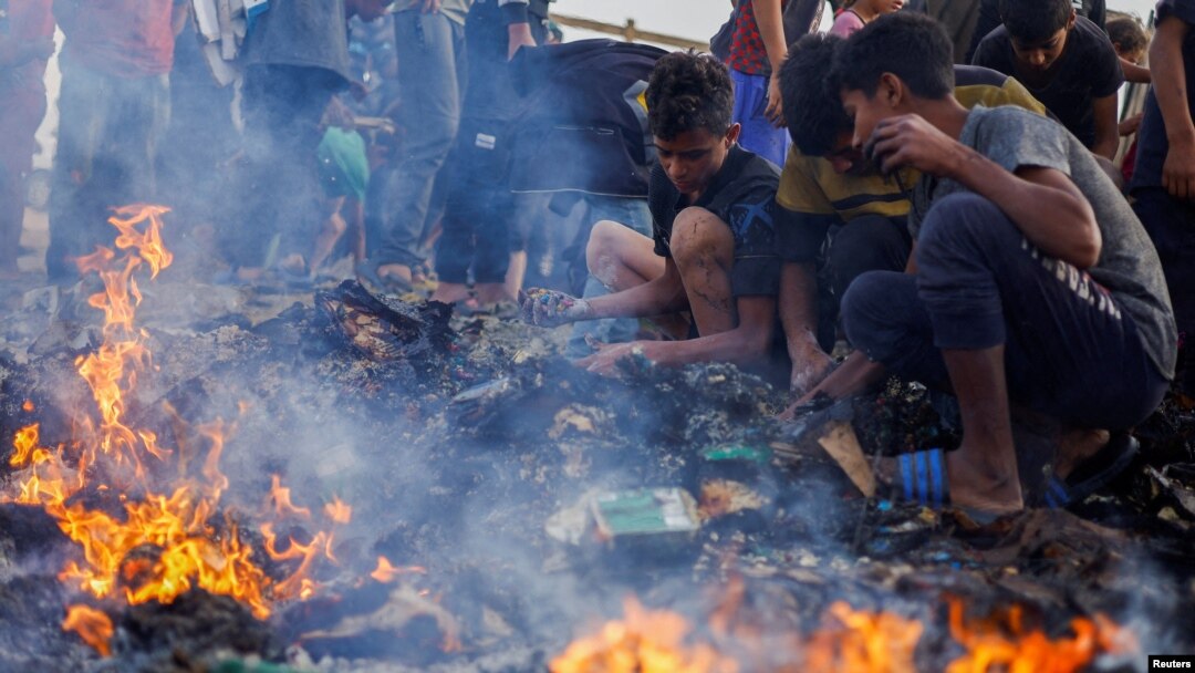 Sejumlah warga Palestina berusaha mencari makanan yang tersisa di antara puing-puing menyusul serangan Israel ke kamp pengungsi di Rafah, di selatan Jalur Gaza, pada 27 Mei 2024. (Foto: Reuters/Mohammed Salem)