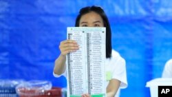 A Thai officer shows a ballot during vote counting at polling station in Bangkok, Thailand, May 14, 2023. 