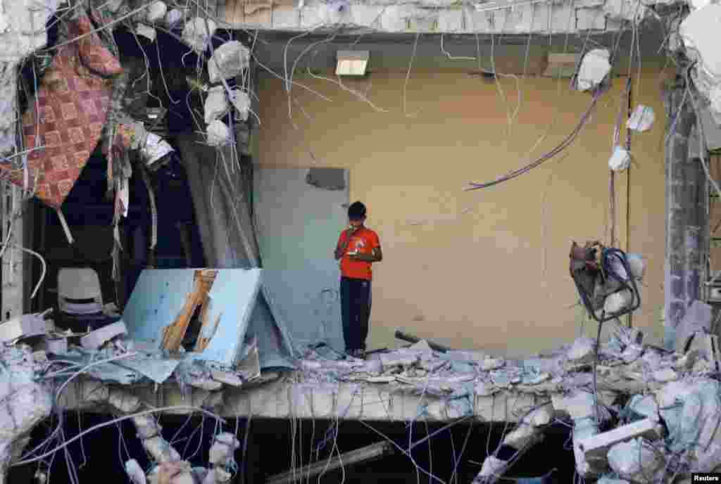 A Palestinian boy stands among rubble, after Israeli forces withdrew from a part of Gaza City, following a ground operation, amid the Israel-Hamas conflict, in Gaza City.