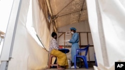 FILE - A health worker attends to an mpox patient at a treatment center in Munigi, eastern Congo, Aug. 19, 2024.