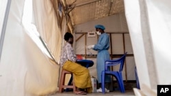 (FILE) A health worker attends to a Mpox patient, at a treatment center in Munigi, eastern Congo, Aug. 19, 2024.