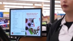 FILE - A woman pays for groceries at a supermarket in Bellflower, Calif., Feb. 13, 2023. 