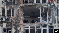 Police inspect an apartment building damaged by a drone, that was shot down during a Russian overnight strike, in Kyiv, Ukraine, Monday, May 8, 2023. 