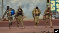 This undated photo provided by the French military shows three Russian mercenaries in northern Mali. Mali and its neighbors have long battled an Islamic extremist insurgency. Ruling juntas have turned to Russia's mercenary units for security assistance.