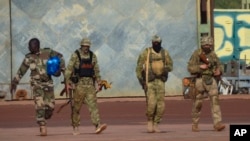 FILE - This undated photo provided by the French military shows three Russian mercenaries in northern Mali. Mali and its neighbors have long battled an Islamic extremist insurgency. Ruling juntas have turned to Russia's mercenary units for security assistance.