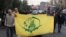 A protester holds the flag of the Afghan Shiite group Liwa Fatemiyoun, a militia formed in 2014 to fight in Syria on the side of the regime, during a protest in support of Yemen and Palestinians, in Tehran, Jan. 12, 2024.