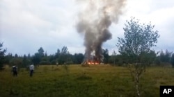 In this image taken from video, smoke and flames rise from a crashed private jet near the village of Kuzhenkino, Tver region, Russia, Wednesday, Aug. 23, 2023. Russian mercenary leader Yevgeny V. Prigozhin, the founder of the Wagner Group, reportedly died when a private jet he was said to be on crashed on Aug. 23, 2023, killing all 10 people on board. (AP Photo)