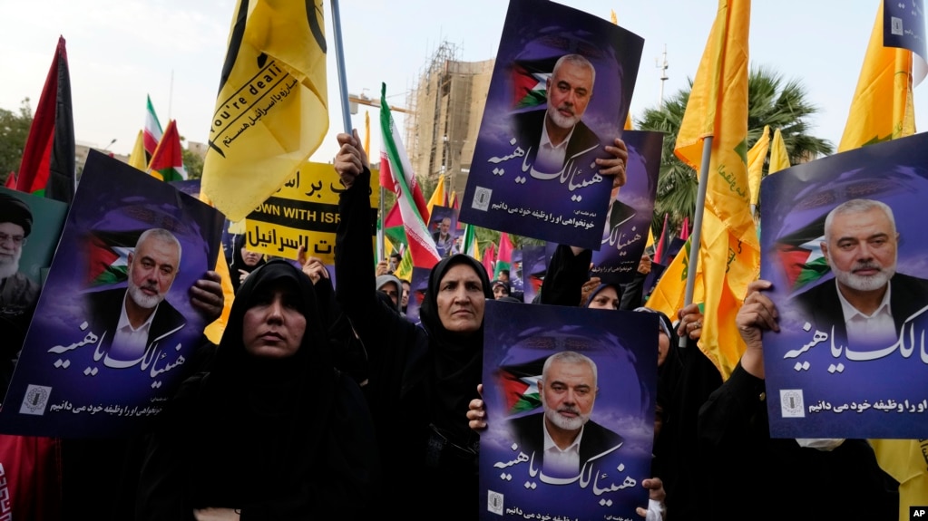 Iranian protesters attend a rally condemning the killing of Ismail Haniyeh as they hold posters of the Hamas leader, in Tehran, Iran, July 31, 2024.