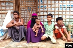Mohammed Eliyeas, a Rohingya refugee, sits with his wife and children outside their damaged shelter in Cox’s Bazar, Bangladesh, after Cyclone Mocha. The catastrophe has caused great emotional and mental distress to the family, among a million other refugees in the country. (Mohammed Rezuwan Khan/VOA)