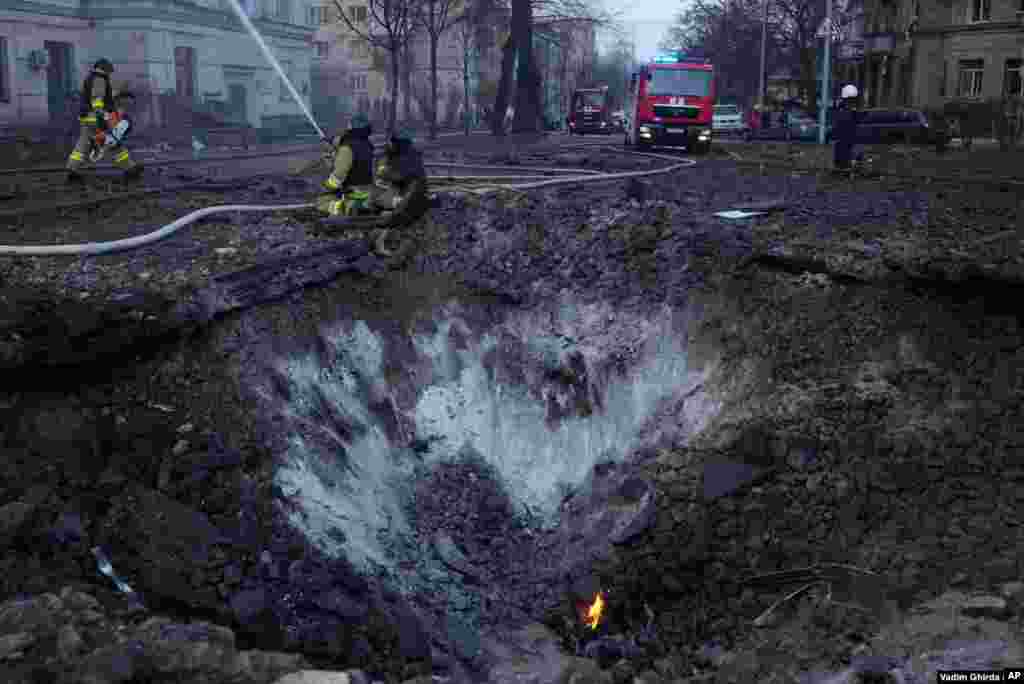 Los bomberos trabajan cerca del cráter de una bomba en Kiev.