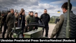 Presiden Ukraina Volodymyr Zelenskiy memeriksa sampel peralatan dan senjata militer terbaru, di tengah serangan Rusia terhadap Ukraina, di wilayah Kyiv, Ukraina, 13 April 2024. (Foto: Layanan Pers Kepresidenan Ukraina via Reuters)