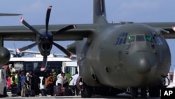 People exit a British military transport aircraft after arriving with approximately 79 British nationals at Larnaca main airport, Cyprus, April 26, 2023.