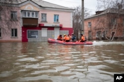 Radnici hitne pomoći i policija voze se čamcem tokom evakuacije nakon pucanja delova brane u Orsku, Rusija, u ponedeljak, 8. aprila 2024.