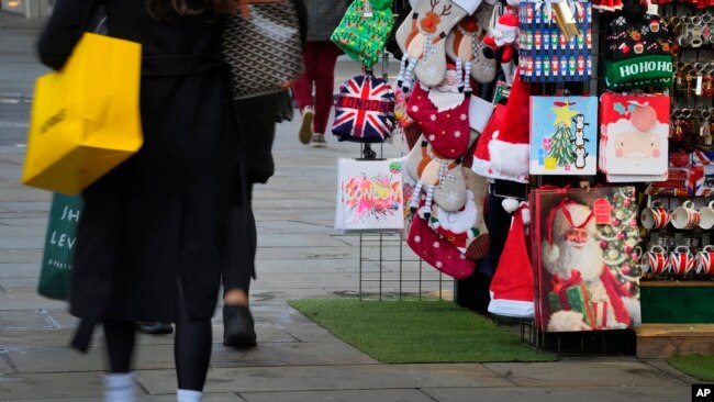 Shoppers pass festive items for sale as they shop on Oxford Street in London, Dec. 20, 2023.