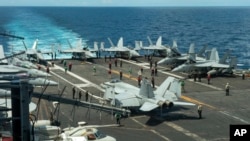 In this photograph released by the U.S. Navy, the flight deck of the Nimitz-class aircraft carrier USS Theodore Roosevelt is seen July 4, 2024, in the South China Sea. 