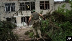 Ukrainian soldiers of the 28th Separate Mechanized Brigade fire a grenade launcher at the front line near the town of Bakhmut, Donetsk region, June 17, 2023.