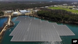 FILE - An array of solar panels float on top of a water storage pond in Sayreville, N.J., Monday, April 10, 2023. (AP Photo/Seth Wenig)
