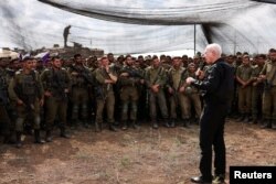 Israel's Defense Minister Yoav Gallant meets soldiers in a field near Israel's border with the Gaza Strip, in southern Israel, Oct. 19, 2023.