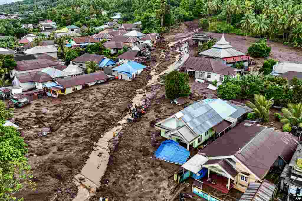 This aerial view shows rescue teams and residents searching for victims buried in mud after a flashflood hit the village of Rua located at the foot of Mount Gamalama, in Ternate, North Maluku, Indonesia.