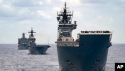 FILE - In this photo undated photo provided by the Australian Defense Force, Royal Australian Navy Ships Canberra, Supply and Warramunga sail in formation with 37 ships during Exercise Rim of the Pacific 2022. 