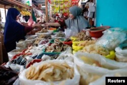 Seorang pedagang melayani pembeli di sebuah pasar tradisional di Jakarta, 2 Januari 2023. (Foto: Ajeng Dinar Ulfiana/Reuters)