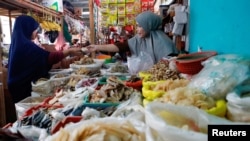 Seorang pedagang tampak melayani pembeli yang datang ke warungnya di salah satu pasar tradisional di Jakarta, pada 2 Januari 2023. (Foto: Reuters/Ajeng Dinar Ulfiana)