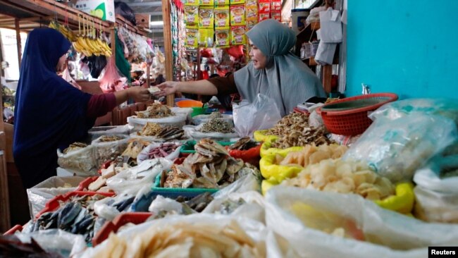 Seorang pedagang sedang melayani pembeli di sebuah pasar tradisional di Jakarta, 2 Januari 2023. (Foto: Ajeng Dinar Ulfiana/Reuters)