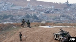 A picture taken in southern Israel near the border with the Gaza Strip on Dec. 24, 2023, shows Israeli soldiers taking a position near the Palestinian enclave. 