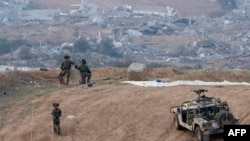 A picture taken in southern Israel near the border with the Gaza Strip on Dec. 24, 2023, shows Israeli soldiers taking a position near the Palestinian enclave.