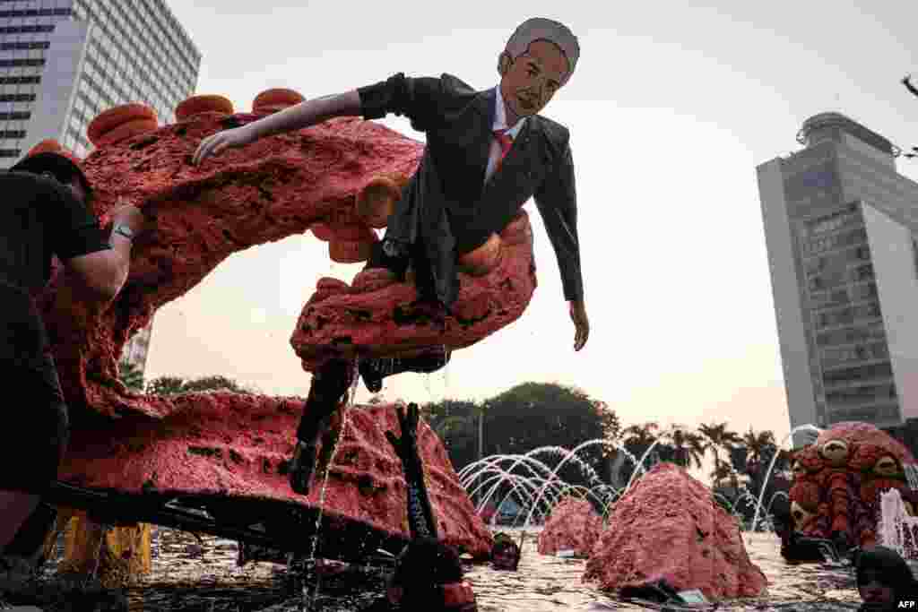 An octopus-shaped figure holds a mannequin resembling Ganjar Pranowo, a potential presidential candidate for the 2024 election, is displayed as Greenpeace activists demonstrate in Jakarta, Indonesia.