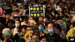 A supporter of the ruling Democratic Progressive Party (DPP) holds a poster with a slogan, ''Hong Kong Yesterday. Taiwan Today,'' outside of the legislative building in Taipei, Taiwan, May 28, 2024.