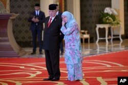 Ratu Malaysia Tunku Azizah Aminah Maimunah Iskandariah, kanan, memeluk kakaknya Sultan Ibrahim Iskandar dari Johor usai pemilihan raja Malaysia berikutnya di Istana Nasional Kuala Lumpur Jumat, 27 Oktober 2023. (Foto: via AP)