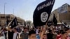 FILE - Demonstrators chant pro-Islamic State group slogans as they carry the group's flags in front of the provincial government headquarters in Mosul, Iraq, June 16, 2014. 