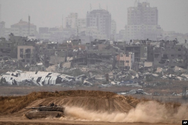 Tentara Israel bergerak di atas tank dekat perbatasan Israel-Gaza, terlihat dari Israel selatan, Kamis, 25 April 2024. (AP Photo/Leo Correa)