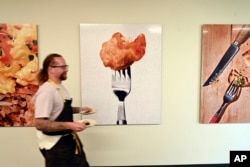 FILE - Chef Zach Tyndall carries plates of cultivated chicken at Good Meat's Alameda, Calif., headquarters, Sept. 28, 2023. Lawmakers in seven states have introduced bills to ban cultivated meat, the National Conference of State Legislatures says.