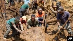 Villagers move a rock as part of search efforts following a devastating landslide, in Yambali village, in the Highlands of Papua New Guinea, May 27, 2024. (Juho Valta/UNDP Papua New Guinea via AP)