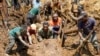 巴布亚新几内亚的村民们在山体滑坡现场移动石块寻找生还者。（2024年5月27日）