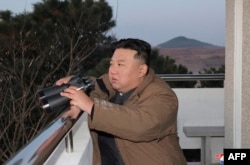 Pemimpin Korea Utara Kim Jong Un menyaksikan peluncuran rudal balistik antarbenua (ICBM) Hwasong-17 dari Bandara Internasional Pyongyang. (Foto: via AFP)