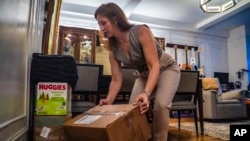 FILE - Jessica Ray moves deliveries from UPS, including baby food and diapers for her child, in her apartment on May 12, 2023, in New York. Ray relies on delivery for nearly everything and is concerned about delays in deliveries should UPS workers strike.