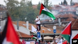 A Bosnian man waves a Palestinian flag during a protest against Israel and in support of Palestinians in Sarajevo, Bosnia, Oct. 22, 2023.
