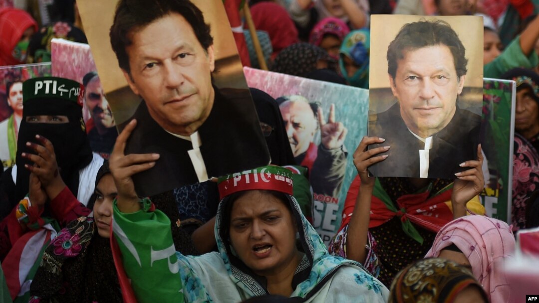 Pendukung mantan perdana menteri Pakistan Imran Khan, membawa poster yang menampilkan potret Khan selama protes di Karachi pada 19 Maret 2023. (Foto: AFP/Rizwan Tabassum)