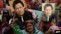 Pendukung mantan perdana menteri Pakistan Imran Khan, membawa plakat yang menampilkan potret Khan selama protes di Karachi pada 19 Maret 2023, menuntut pembebasan anggota partai yang ditangkap dalam bentrokan polisi baru-baru ini. (Foto: AFP/Rizwan TABASSUM)